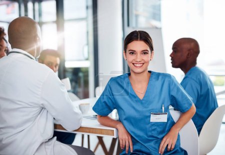 Photo for She shows a lot of charisma in her job. Portrait of a cheerful young doctor seated at a table during a meeting inside of a hospital during the day - Royalty Free Image