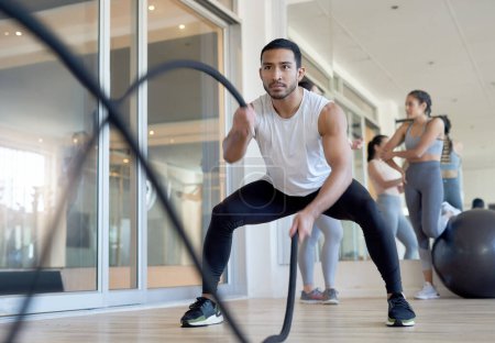 Foto de Aparecer y darlo todo. un hombre que usa cuerdas de batalla mientras hace ejercicio en el gimnasio - Imagen libre de derechos