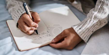 Foto de El cambio comienza hoy. un hombre escribiendo en un cuaderno en su cama en casa - Imagen libre de derechos