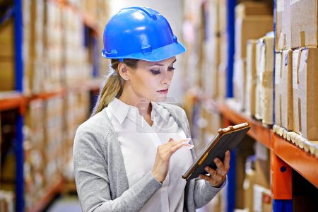 Photo for Tracking your order to its destination. a woman at work in a storage warehouse - Royalty Free Image