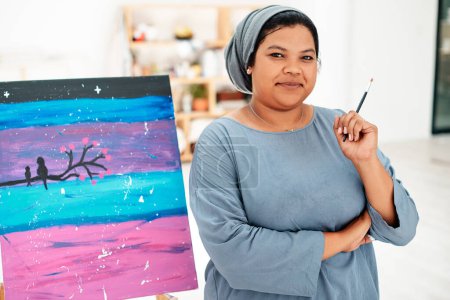 Photo for I prefer to live my life in colour. Cropped portrait of an attractive young artist standing next to her painting during an art class in the studio - Royalty Free Image