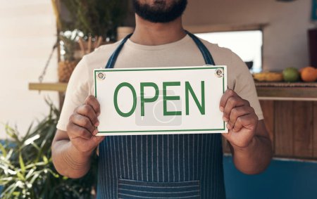 Photo for Finally able to put this sign up. a businessman holding an open business sign - Royalty Free Image