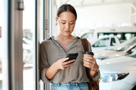 Photo for Cellphone, coffee and female person in a showroom typing a text message or scrolling on social media. Communication, technology and woman browsing on a mobile app with a cellphone at a car dealership. - Royalty Free Image