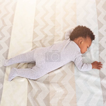 Téléchargez les photos : Vue de dessus, lit et bébé dormant dans la crèche avec lentille fusée éclairante pour se reposer, faire la sieste et rêver à la maison. Garde d'enfants, nouveau-né et mignon, enfant fatigué et africain dans la chambre à coucher dormir pour le confort, se détendre et calme. - en image libre de droit