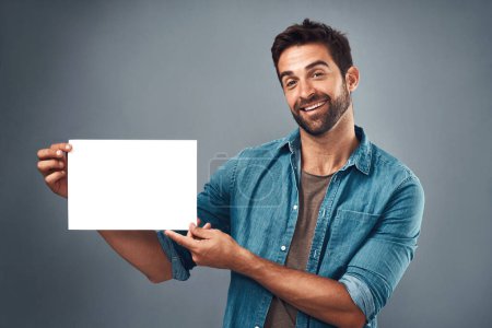 Photo for Happy man, billboard and mockup for advertising, marketing or branding against a grey studio background. Portrait of male person holding rectangle poster, placard or board of empty sign for message. - Royalty Free Image