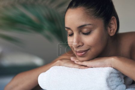 Téléchargez les photos : Ferme les yeux et concentre-toi sur toi. une jeune femme allongée sur un lit de massage dans un spa - en image libre de droit