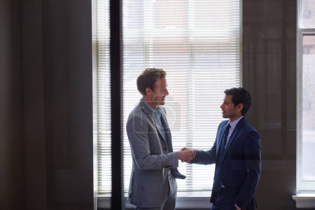 Foto de Parece que tenemos un trato. dos hombres de negocios estrechando la mano en la oficina - Imagen libre de derechos