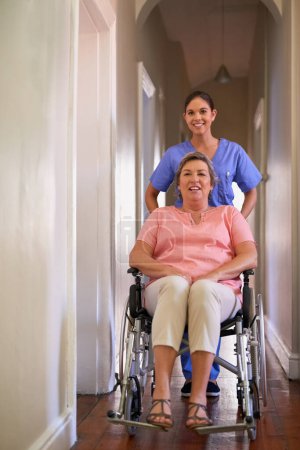 Foto de Mujer feliz, silla de ruedas y enfermera con ayuda de atención domiciliaria, servicio de salud y apoyo a la discapacidad. Cuidador, paciente discapacitado o persona mayor, seguro de salud y hogar, administración y rehabilitación. - Imagen libre de derechos