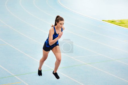 Photo for Woman, running and stadium track of athlete in fitness, exercise or workout for cardio training outdoors. Fit, active or sporty female person, runner or sprinting competition for exercising or race. - Royalty Free Image