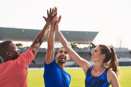 Photo for Diversity, team and high five on stadium track for running, exercise or training together in athletics. Group touching hands in celebration or solidarity for exercising, run or winning in fitness. - Royalty Free Image