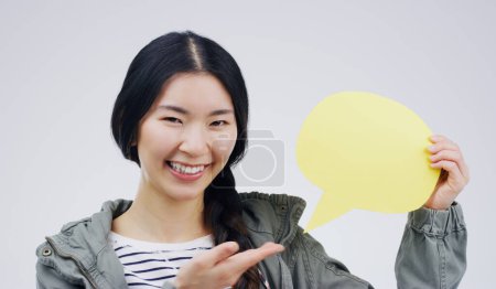 Téléchargez les photos : Joyeux asiatique femme, sourire portrait et bulle de parole pour la question, FAQ ou les médias sociaux sur un fond de studio blanc. Femme excitée souriant avec signe pour commentaire, message ou espace de maquette. - en image libre de droit