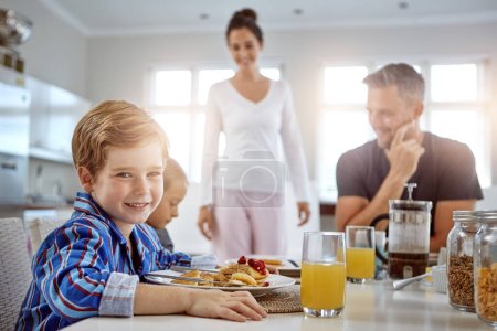 Photo for Child, portrait and pancakes for breakfast in a family home with love, care and happiness at a table. A happy woman, man and kids eating food together in morning for health, happiness and wellness. - Royalty Free Image