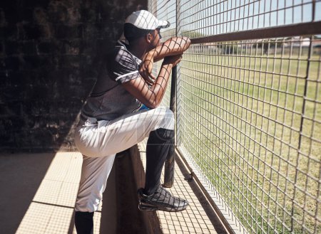 Téléchargez les photos : Là où est l'action. un jeune homme regardant un match de baseball derrière la clôture - en image libre de droit