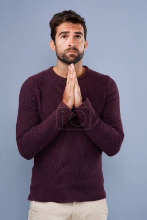Photo for Praying for strength and guidance. Studio shot of a handsome young man praying against a gray background - Royalty Free Image