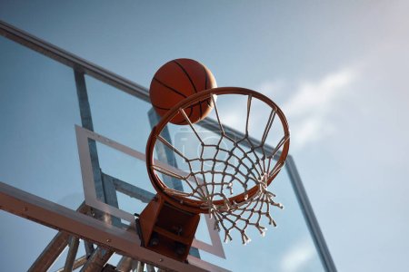 Photo for Shoot for the sky and you will score. Closeup shot of a basketball landing into a net on a sports court - Royalty Free Image