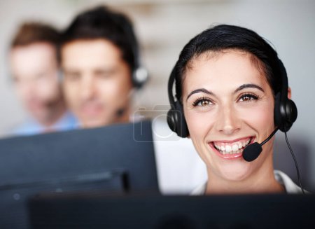 Photo for She revels in her communication occupation. Portrait of a pretty call center agent wearing a headset and sitting in front of her computer - Royalty Free Image