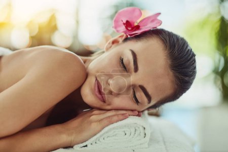Téléchargez les photos : Le stress fond sur une table de massage. une jeune femme attrayante se faire dorloter dans un spa de beauté - en image libre de droit
