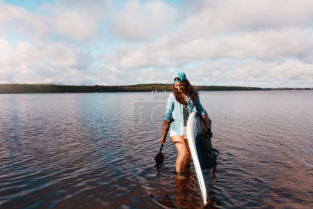 Téléchargez les photos : J'adore être dans l'eau. une jeune femme pagaie sur un lac - en image libre de droit