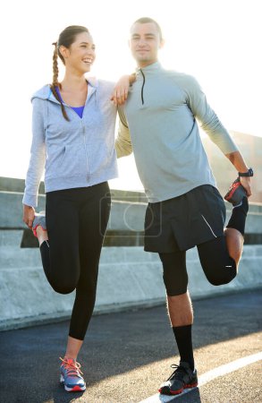 Téléchargez les photos : S'étirer avant un long jogging. Portrait de deux amis s'étirant ensemble avant une course dans les rues de la ville - en image libre de droit