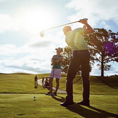 Foto de Se pone cada vez mejor y mejor. una pareja jugando al golf juntos en un fairway - Imagen libre de derechos