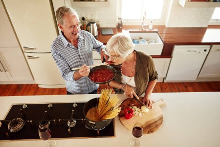 Photo for Top view, tasting or old couple kitchen cooking with healthy food for lunch or dinner together at home. Love, taste or senior woman helping or eating with mature man in meal preparation in retirement. - Royalty Free Image