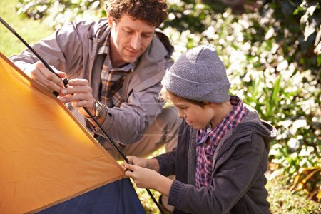 Photo for Dad, kid and set up tent for camping outdoor in nature on vacation while bonding in summer. Father, boy and preparing campsite, learning and helping in forest for travel, education and holiday - Royalty Free Image