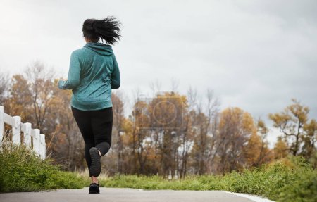 Photo for Summer bodies are made all year round. Rearview shot of a young woman going for a run in nature - Royalty Free Image
