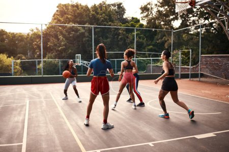 Photo for This is so challenging. a diverse group of sportswomen playing a competitive game of basketball together during the day - Royalty Free Image
