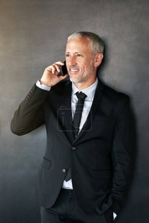Photo for Happy businessman, phone call and thinking with communication, contact and network in studio. A senior entrepreneur person on a grey background with a smartphone for conversation and connection. - Royalty Free Image