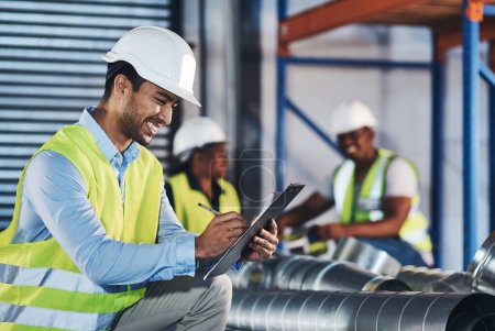 Photo for Everything seems to be here. a handsome young contractor crouching down and doing a stock-take in the warehouse - Royalty Free Image