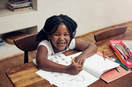 Foto de Hacer mi tarea no es tan malo. Retrato de una adorable niña dibujando y haciendo sus deberes en casa - Imagen libre de derechos