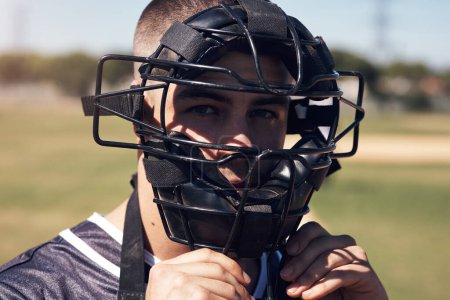 Téléchargez les photos : Regarde-moi écrire l'histoire du baseball. Portrait d'un jeune homme portant un casque d'attrapeur tout en jouant à un jeu de baseball - en image libre de droit