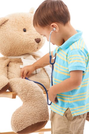 Photo for Playing doctor. Studio shot of a young boy playing with his teddy bear and a stethoscope - Royalty Free Image