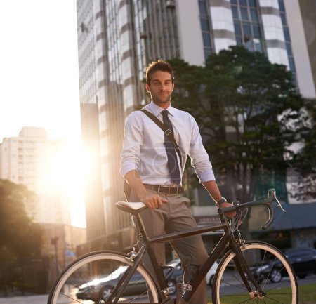 Téléchargez les photos : Cyclisme, portrait et homme d'affaires en ville pour le trajet, neutre en carbone et les transports. Durable, professionnel et voyage avec un employé masculin marchant à vélo dans la ville urbaine pour le voyage et le voyage. - en image libre de droit