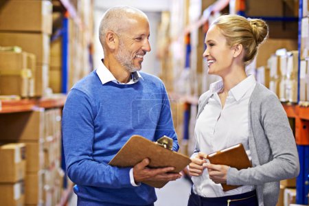 Foto de Coordinando el envío. un hombre y una mujer inspeccionando el inventario en un gran almacén de distribución - Imagen libre de derechos