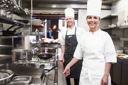 Téléchargez les photos : De notre cuisinière à votre table à manger. Portrait de chefs dans une cuisine professionnelle - en image libre de droit