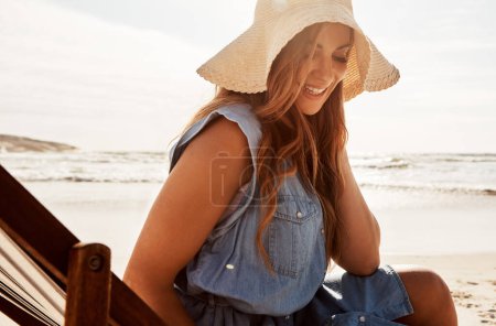 Foto de A menudo la encontrarás descansando en la playa. una joven relajándose en una tumbona en la playa - Imagen libre de derechos