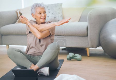 Téléchargez les photos : Je suis toujours plutôt tendance. une femme plus âgée faisant des exercices légers au sol à la maison - en image libre de droit