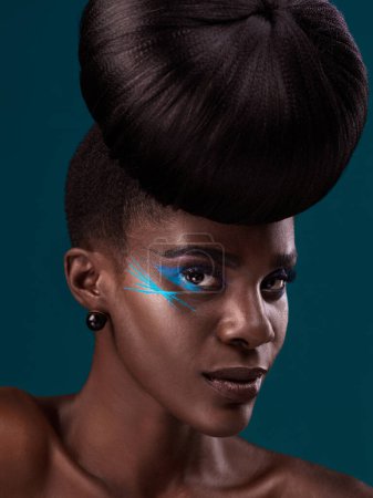 Téléchargez les photos : Portrait, cheveux et cosmétiques avec un mannequin femme noire en studio sur fond bleu pour la beauté. Visage, soins capillaires et maquillage avec une jeune femme séduisante au salon de mode ou de coiffure. - en image libre de droit