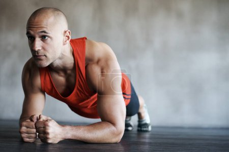 Photo for Fitness, man and plank in workout, exercise or training for strong core, abs or determination at gym. Serious, fit and confident male personal trainer working on abdominal muscle for healthy wellness. - Royalty Free Image