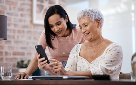 Photo for Helping mom make healthy financial choices. a young woman using a smartphone with her elderly mother while going through finances at home - Royalty Free Image