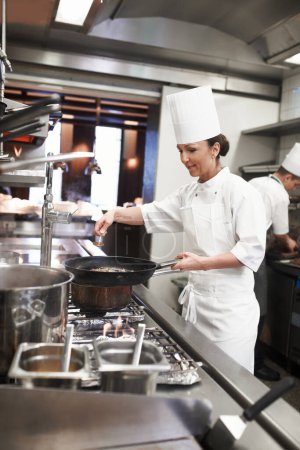 Photo for Chef, woman and frying pan with sauce in restaurant kitchen, catering service and prepare food for fine dining. Professional, cooking and female saucier or person with meat meal for hospitality - Royalty Free Image