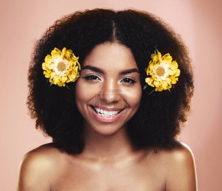 Photo for Portrait of happy woman, afro and yellow flowers in studio background for beauty, floral aesthetic and shine. Face of african model, skincare and daisy plants in hair for happiness, perfume or makeup. - Royalty Free Image