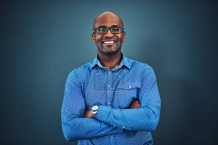 Photo for Business, black man and portrait with arms crossed in a studio feeling proud from auditor work. Blue background, smile and African employee with success and leadership vision with glasses and idea. - Royalty Free Image