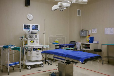 Photo for Prepped for a surgical procedure. monitoring equipment and a bed in an empty hospital ward - Royalty Free Image