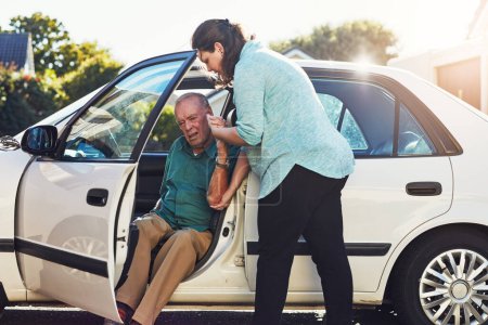 Photo for Lets get you out of there. a woman helping her senior father out of the car - Royalty Free Image