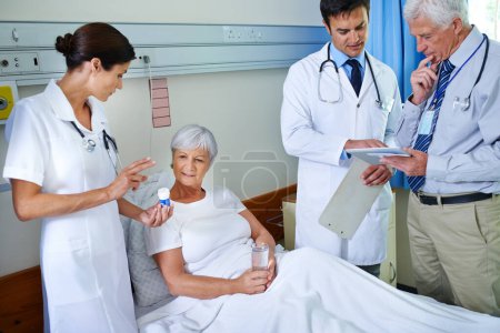 Photo for All minds needed in the search for a cure. three doctors attending a senior patient who is in a hospital bed - Royalty Free Image