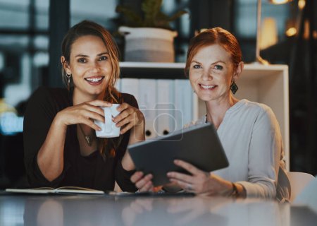 Photo for When were looking for some inspiration, we just switch this on. Portrait of two businesswomen using a digital tablet together in an office at night - Royalty Free Image