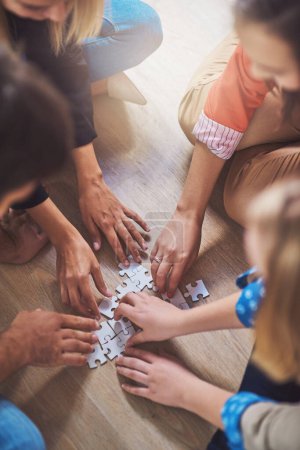 Photo for Top view, people and hands with puzzle for teamwork, solution and problem solving for innovation. Closeup, team building and planning jigsaw for integration, collaboration and synergy for cooperation. - Royalty Free Image
