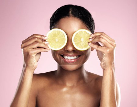 Photo for Happy woman, beauty and eyes with lemon in studio, pink background and vitamin c benefits. Face, african model and fun with citrus fruits for natural skincare, vegan cosmetics and facial aesthetic. - Royalty Free Image